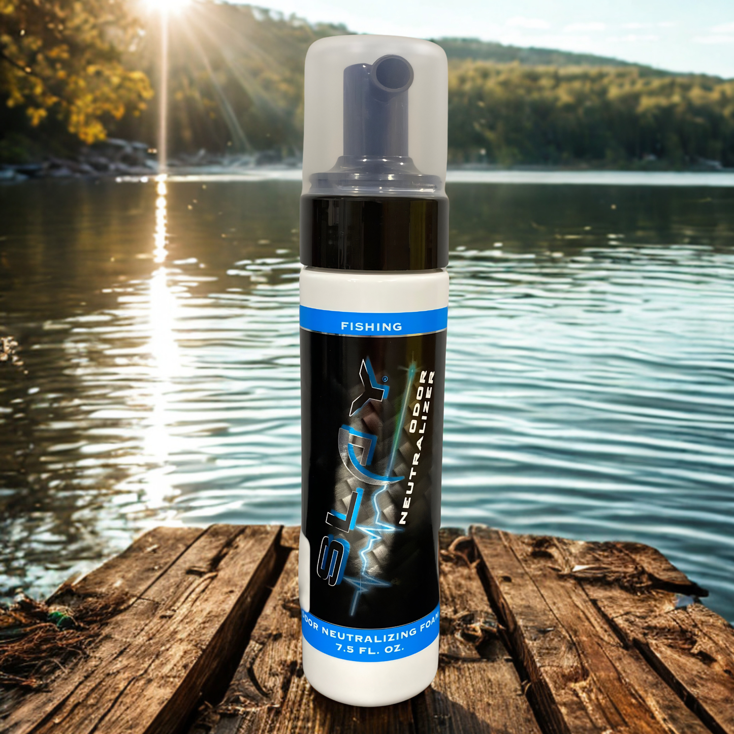 Slay odor neutralizing foam bottle placed on a wooden fishing dock for scent control before fishing. Lake and trees in the background.