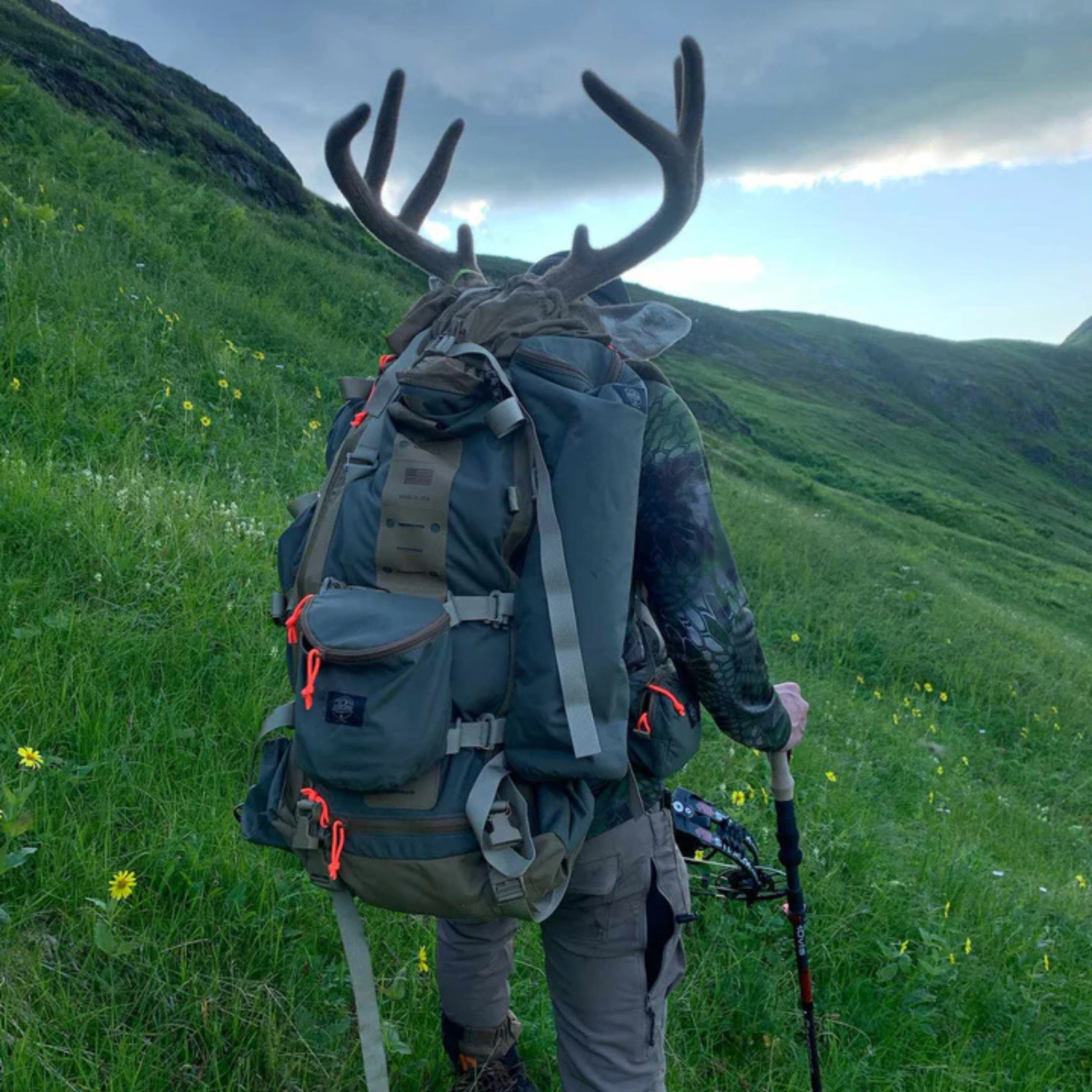 Hunter wearing the Alaska Guide Creations Kobuk 42 pack while hiking through mountain terrain