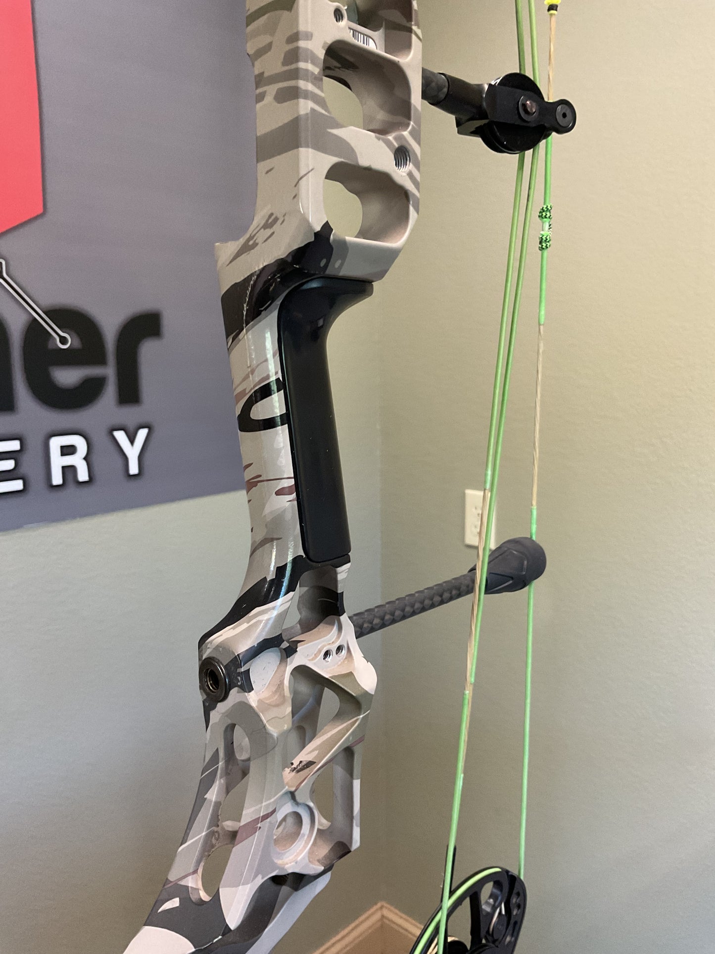 Black Handle grip on a used Mathews Archery Compound bow in camo.