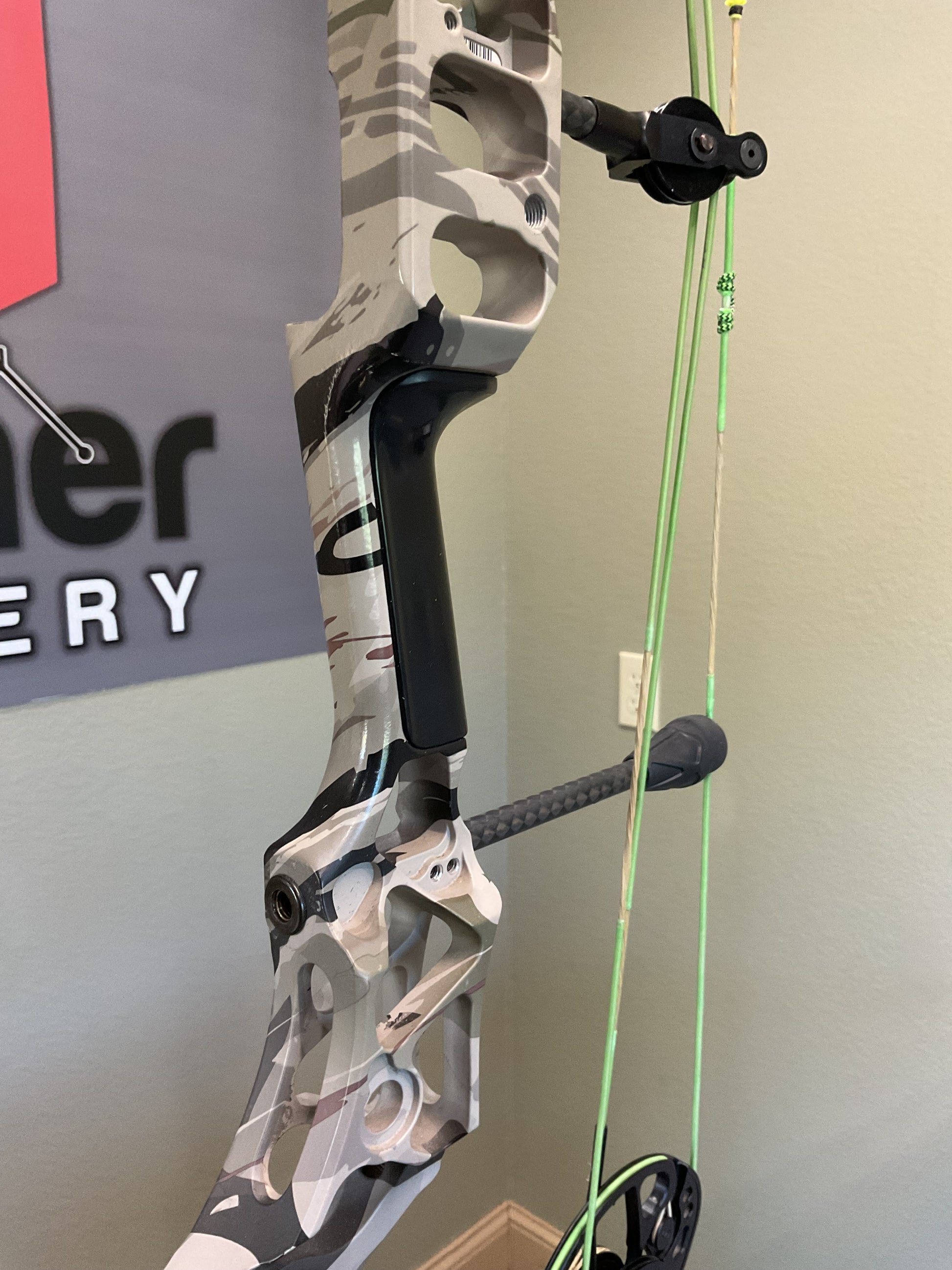 Black Handle grip on a used Mathews Archery Compound bow in camo.