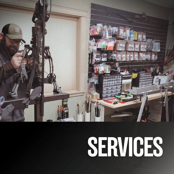 Man working on a crossbow in an archery shop with a bow press and tools.